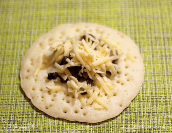 В центр блина кладем 1 ст. л. грибной начинки, посыпаем сыром.