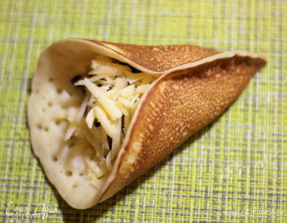 Защипываем края блинчика с одной стороны почти до середины, получается как бы кулечек.