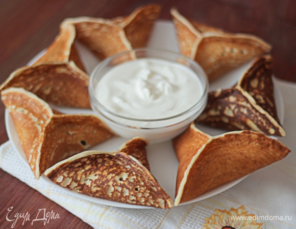 Складываем треугольнички на противень и отправляем в разогретую до 200°C духовку на 7–10 минут. Блинчики получаются с хрустящей корочкой и расплавленным сыром внутри.