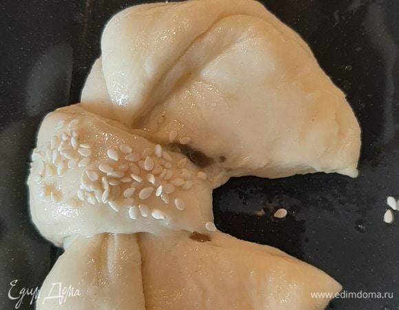 Сворачиваем бантиком, выкладываем на противень. Накрываем и даем постоять минут 10. Потом смазываем яйцом и посыпаем кунжутом.