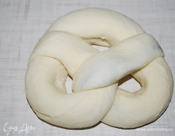 И сформируйте бублик-брецель. Края хорошо защипните, чтобы они при выпечке не разошлись. И даже если во время выпечки шоколадное тесто будет сочиться из булочек, это только придаст им красоты.