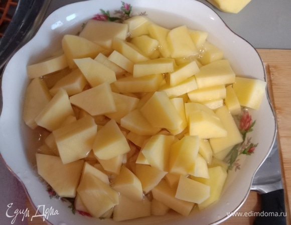 Вначале нарезаем картошку на брускеты, как показано на фото. Далее — важный момент: картошку помещаем в тарелку и заливаем водой минут на 15–20, чтобы вышел лишний крахмал, который мог бы добавить блюду ненужный неприятный привкус. Кстати, лучше использовать молодой картофель, но и другой имеет место быть.