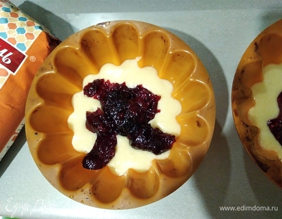 Духовку разогреть до 180°C. Приготовить маленькие формочки для маффинов или 2 средние, как у меня. На дно формочек налить тесто (примерно по 4–5 ложек). Сверху положить джем или варенье. Я брала малиновое варенье и джем из жимолости.