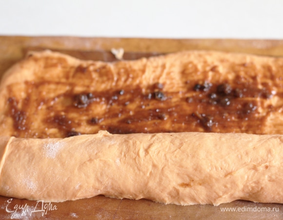 Смазать смесью равномерно поверхность теста. Тесто скатать по широкой кромке. В конце получился рулет примерно 45 см в длину.