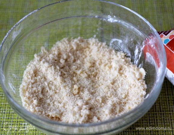В это время готовим песочную основу. Муку просеять с разрыхлителем, добавить сахар и холодное сливочное масло, растереть в мелкую крошку.