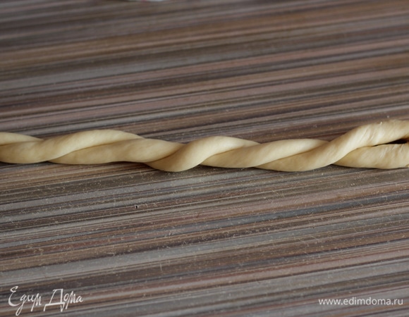 Кусочек теста раскатываем в тонкий жгут длиной 70–80 см, складываем пополам и перекручиваем.