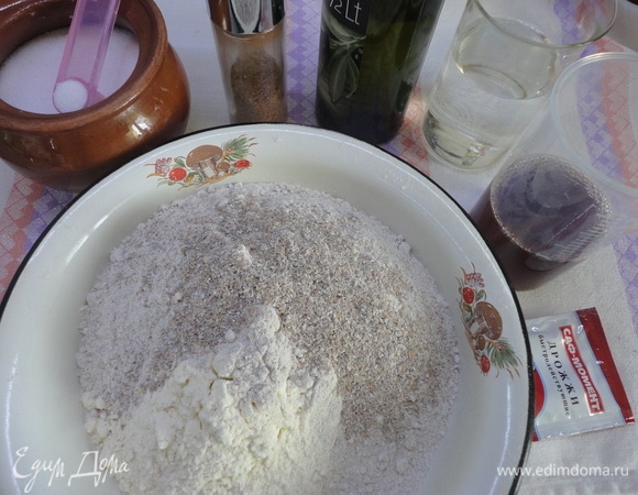 Оба вида муки просеять и соединить с отрубями, кориандром и солью. Высыпать в форму для запекания. Вылить сверху все жидкие ингредиенты, а дрожжи — в диспенсер.