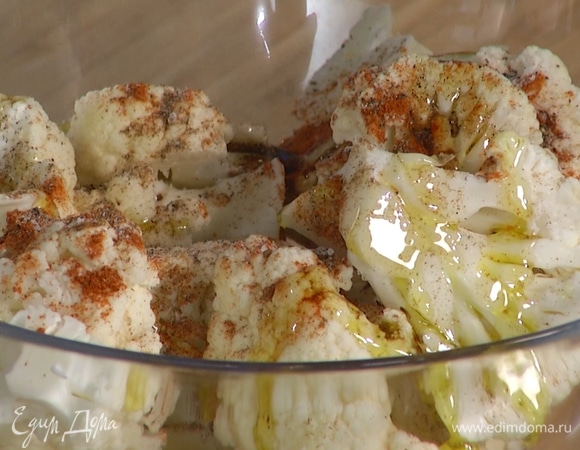 Цветную капусту нарезать на ломтики, заправить специями и 1 столовой ложкой оливкового масла, перемешать.