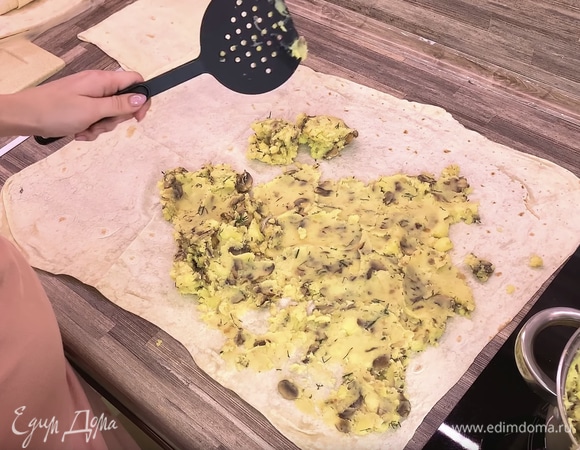 Разворачиваем лаваш и размазываем по нему 50% начинки, затем накрываем еще одним слоем лаваша и снова размазываем оставшуюся часть начинки.