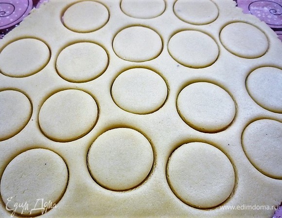 Замешиваем однородное тесто, заворачиваем в пищевую пленку и убираем на час в холодильник. Раскатываем пласт толщиной 5–7 мм и с помощью формы или стакана вырезаем небольшие кружки диаметром примерно 4 см.