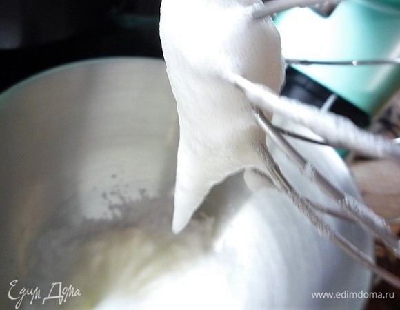 В чашу комбайна выкладываем яичный белок (70 г) и сахар (7 г). Начинаем взбивать на средней скорости до мягких пиков. Как только сироп достигнет температуры 117°C, снимаем его с огня, увеличиваем скорость миксера на максимальную и тонкой струйкой медленно вливаем сироп в белок.