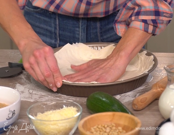 Пласт теста раскатать скалкой, выложить в форму для выпекания. Лишние части теста отрезать.