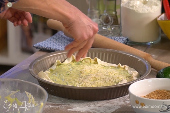 Начинку выложить на тесто, равномерно распределить, завернуть края теста внутрь. Пирог сверху посыпать остатками сыра.