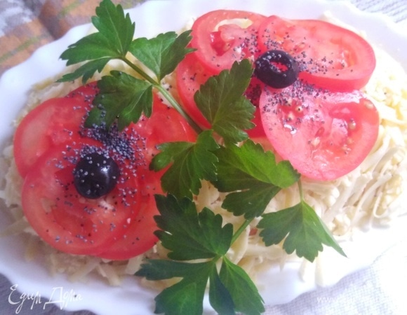 Украсить салат. Из черри сделать цветы. Добавить веточку зелени. Маслины разрезать пополам, сделать серединку цветка. Посыпать маком. Дать настояться салату в течение 1 часа.