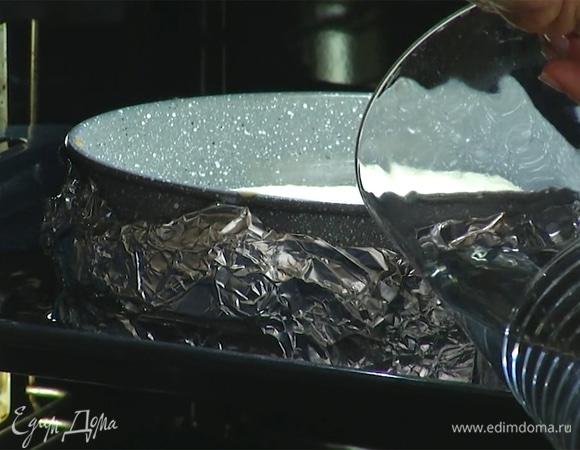 Форму с чизкейком поставить в глубокий противень, задвинуть его на 2/3 в духовку и влить в противень холодную воду так, чтобы форма была покрыта на четверть.