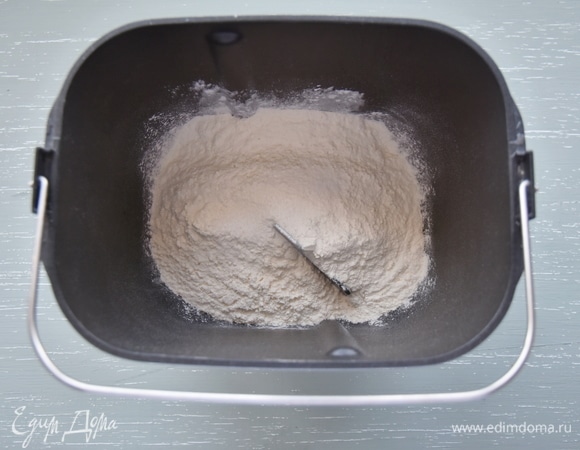 В емкость установить лопатку для замешивания теста, всыпать муку.