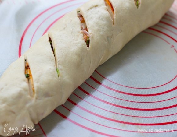 Скатать в рулет по той стороне, по которой он будет помещаться на противень. Духовку разогреть до 180°C. На поверхности рулета сделать резаные насечки. Концы рулета заправить внутрь. Накрыть, дать подойти 30–40 минут. Поверхность смазать смальцем или маслом. Можно также желтком.