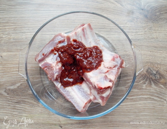 Свиные ребра вымоем, обсушим и посолим. Затем положим часть соуса и равномерно нанесем да ребра.
