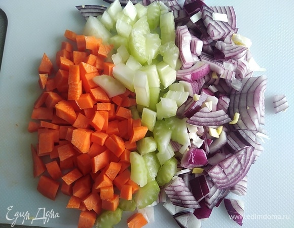 Нарезать сельдерей, лук и морковь. Разогреть масло в сковороде. Готовить овощи 4 минуты, помешивая.