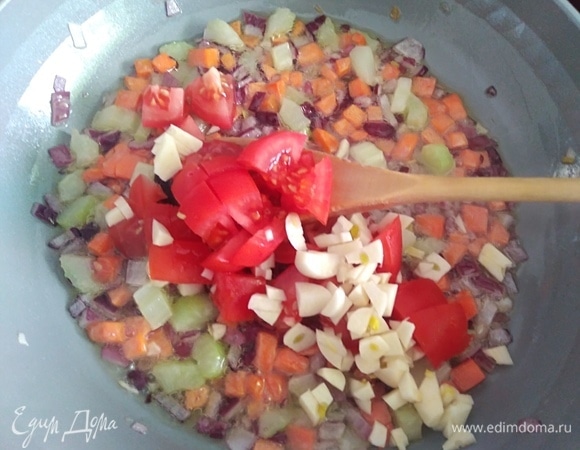 Помидор и чеснок тоже нарезать. Добавить в сковородку. Готовить минуту.