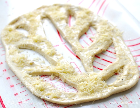 Разогрейте духовку до 200°C. Смажьте поверхность теста оливковым маслом и посыпьте по вкусу сыром.