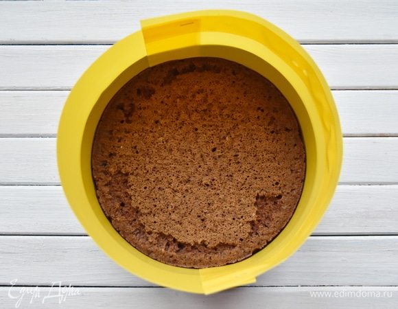 Остывший бисквит уложить на дно разъемной формы. Для удобства бока формы проложить ацетатной пленкой или, как у меня, подручным материалом.