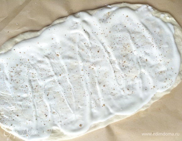Руками растягиваем тесто на бумаге. У меня 2 пирога. Один я смазала сметаной, сверху посолила и поперчила.