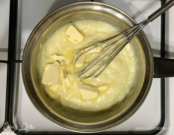 Добавить мягкое сливочное масло, нарезанное на кусочки, быстро перемешать до однородности. Накрыть пленкой в контакт (так, чтобы пленка касалась крема), дать полностью остыть.