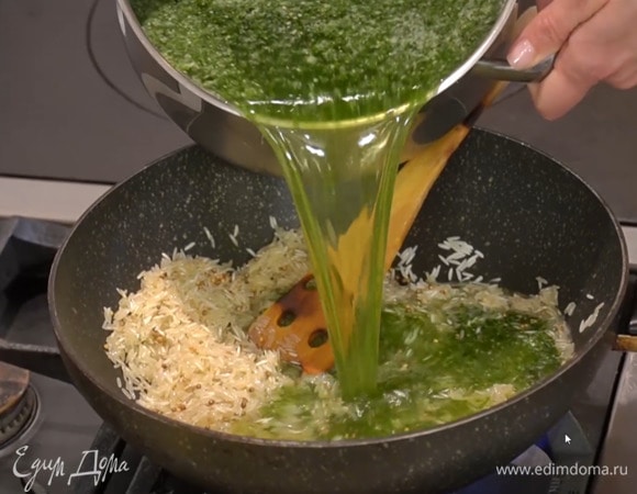Влить в сковороду зеленый овощной бульон так, чтобы рис был покрыт на три пальца, и, не накрывая крышкой, на небольшом огне довести до готовности.