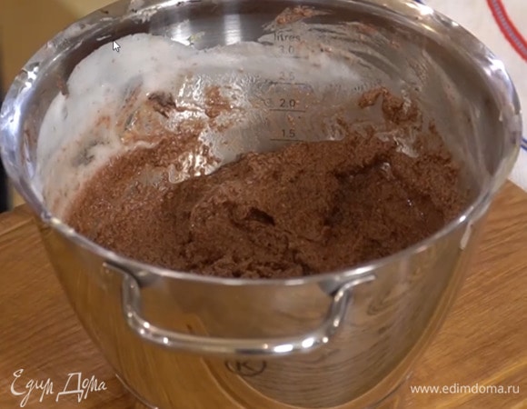 Продолжая взбивать, по одному ввести желтки, добавить заваренное в кипятке какао, порциями всыпать измельченные орехи и все взбить, затем небольшими порциями добавить взбитые белки и вымешать лопаткой.