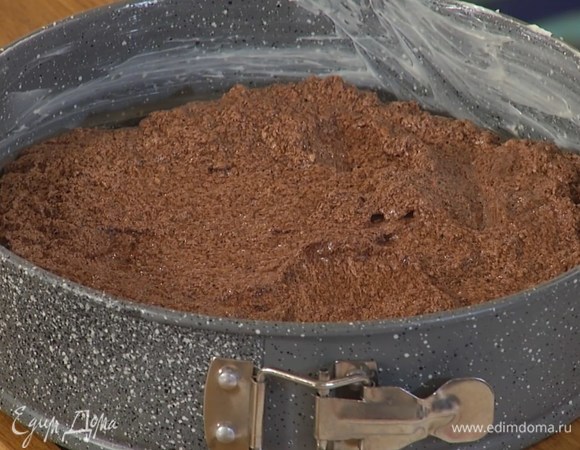 Разъемную форму для выпечки смазать оставшимся сливочным маслом, выложить шоколадное тесто и разровнять его лопаткой.