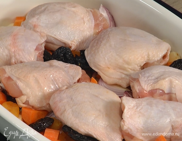 Подготовленные овощи выложить в форму для запекания, разложить на них курагу и чернослив, а сверху куриные бедра.