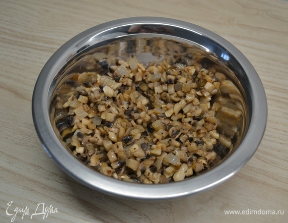 Лук и грибы нарезать мелким кубиком и обжарить до золотистости. Добавить измельченный чеснок, соль и перец. Обжарить еще около минуты.