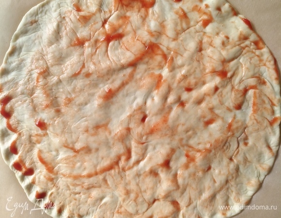 Теперь приступим ко второй пицце с салями. Тесто смазываем томатным соусом.