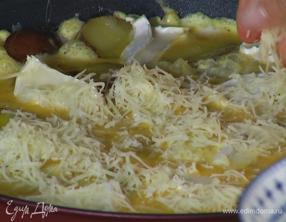 Когда фриттата немного схватится по краям, поставить сковороду в разогретую духовку, через несколько минут посыпать блюдо натертым сыром и запекать еще 2 минуты.