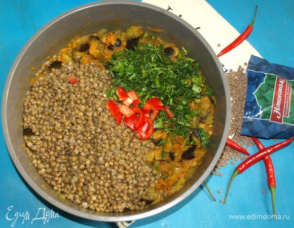 В глубокой сковороде разогреть растительное масло. Добавить лук, чеснок и морковь. Готовим 5–7 минут. Добавляем баклажаны и готовим до мягкости. Добавляем помидоры, соль, перец, карри и готовим 10 минут. Во время томления овощей, если необходимо, добавлять по частям оставшийся чечевичный отвар. Добавляем зелень, чечевицу и острый красный перец. Все перемешиваем и томим пару минут.
