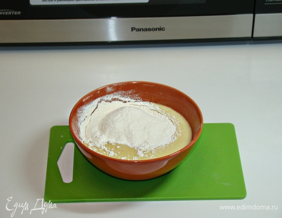 В остывшую смесь всыпать половину нормы муки и перемешать. Остальную часть муки насыпать на стол и на нее выложить тесто. Замесить мягкое эластичное тесто, оно практически не липнет к рукам.