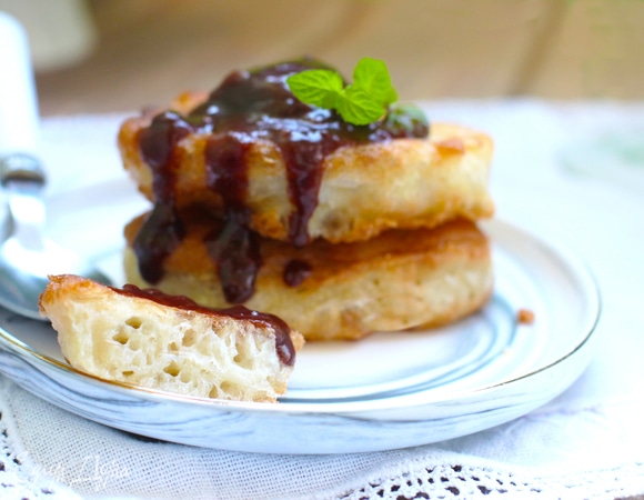 Размешивать его нельзя, это очень важно! Нужно набирать тесто ложкой с самого края, как бы отрезая его краем ложки, и выкладывать на сковородку с разогретым маслом. Жарим на небольшом огне, можно накрывать сковородку крышкой. Аккуратно переворачиваем на другую сторону и еще поджариваем. Крышка помогает оладьям хорошо пропечься.