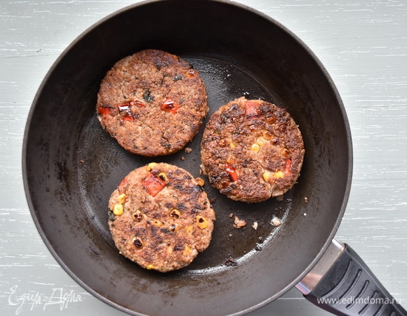 Сформировать котлеты, запанировать их в муке и перед обжариванием выдержать некоторое время в морозильной камере. Обжарить до золотистого цвета на сковороде с растительным маслом. Когда все составляющие гамбургера будут готовы, останется только собрать его. В качестве дополнения можно использовать все, что любите: маринованные огурцы, помидоры, лук, листья салата.