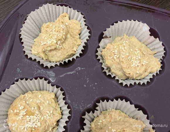 Смазываем формочки для запекания растительным маслом, либо можно использовать бумажные формы для кексов. Готовое тесто выкладываем на смазанную растительным маслом поверхность, разделяем на порционные части, раскладываем по формам, посыпаем кунжутом ТМ «Националь» и дает подойти еще минут 10–15. Выпекаем в горячей духовке около 20–25 минут.