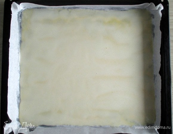 Перелейте тесто на промасленный или лучше на проложенный пекарской бумагой противень. Размеры противня — около 30х36 см, но могут варьироваться. Минут через пять поместите противень в разогретую духовку.