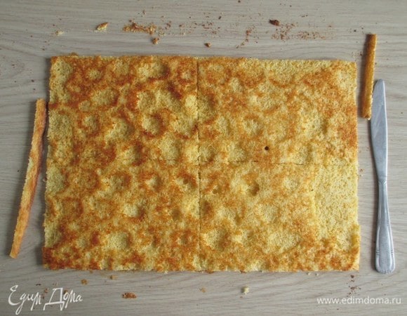 Подровняйте края кукурузного коржа и разделите его на четыре равные заготовки. Обрезки коржа можно или просто съесть, или подсушить в духовке, потом измельчить и использовать для обсыпки боков этого торта.