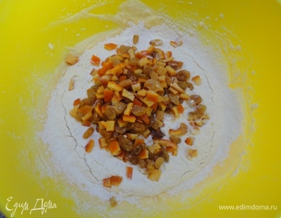 К яично-масляной массе добавить цедру апельсина, аккуратно просеять сухую смесь, а также цукаты и изюм.