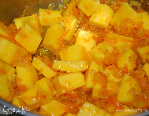 Тыкву нарежьте кубиками и добавьте в кастрюлю к моркови и луку.
