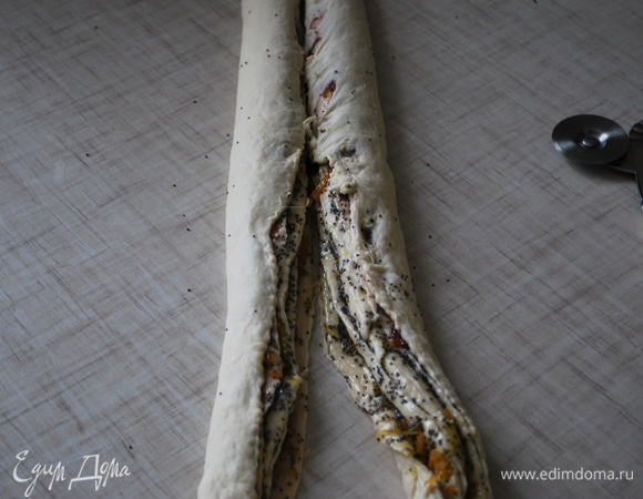 Разрежьте скрученный рулет не до конца. Скрутите его косичкой.