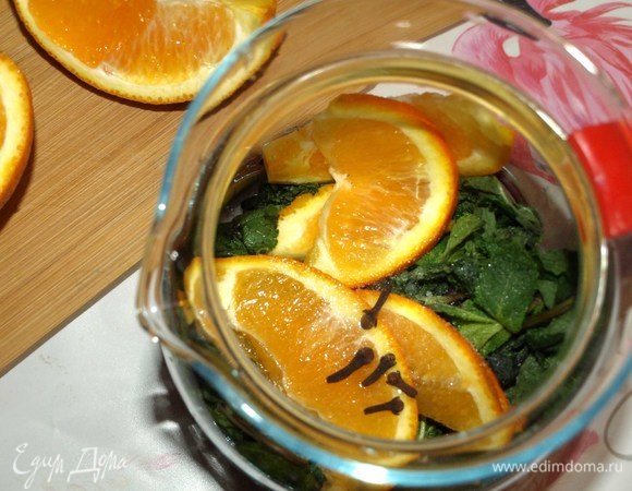 Мяту залить холодной водой на 5–10 минут, чтобы ушла горечь и в напитке присутствовал мягкий мятный вкус. Мяту освободить от лишней воды. Апельсин нарезать тонкими дольками. Все складываем в чайник, добавляем гвоздику, порошок стевии (подсластитель можно заменить на свой вкус).