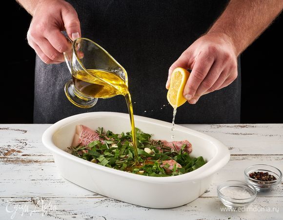 Выложите рыбу в форму. Добавьте травы, сок лимона, оливковое масло, соль, перец и перемешайте. Оставьте мариноваться на 10 минут.