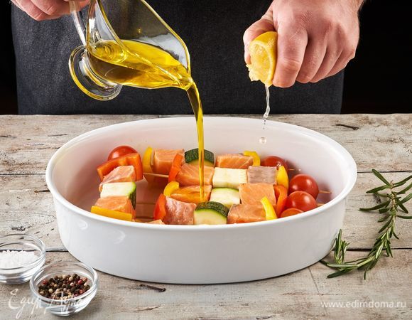 На деревянные шпажки нанижите, чередуя между собой, рыбу и овощи. Затем переложите в форму, посолите, поперчите, выдавите сок лимона, порвите веточку розмарина и налейте оливковое масло. Оставьте мариноваться на полчаса.