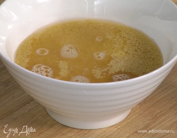 Овощной бульон разогреть и залить им кускус так, чтобы он был полностью покрыт, накрыть крышкой или пищевой пленкой и дать постоять, пока жидкость полностью не впитается.