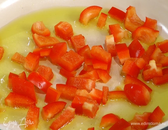 Разогреть в сковороде 2 ст. ложки оливкового масла и обжарить нарезанный перец.